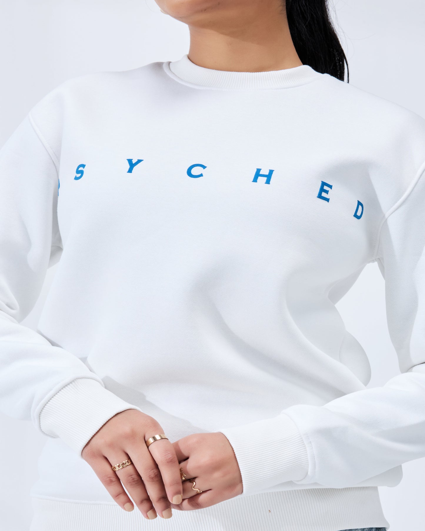 White sweatshirt with blue text worn by a person on a white background