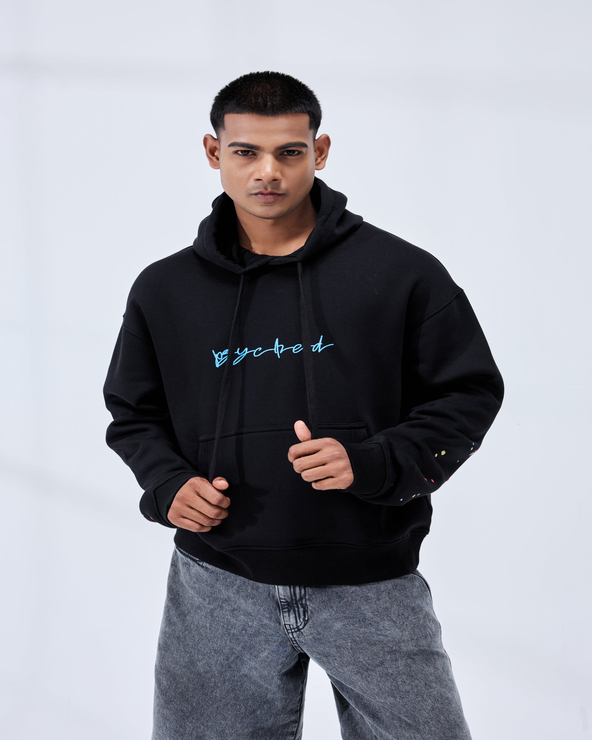 Man wearing a black hoodie with a logo on a white background